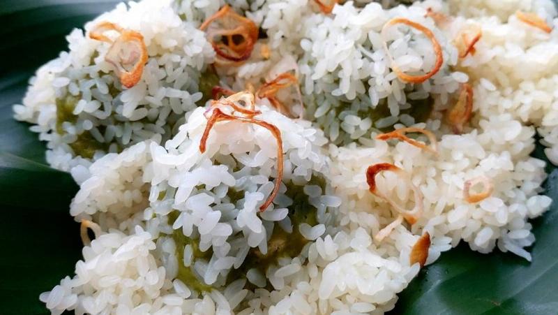 Một đĩa xôi khúc nóng hổi được bọc trong lá chuối, bày bán ăn đêm ở Hà Nội, hạt xôi dẻo thơm và nhân đậu xanh.